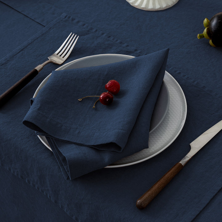 Deep navy linen napkin, adding a bold and sophisticated touch to a formal dining table.