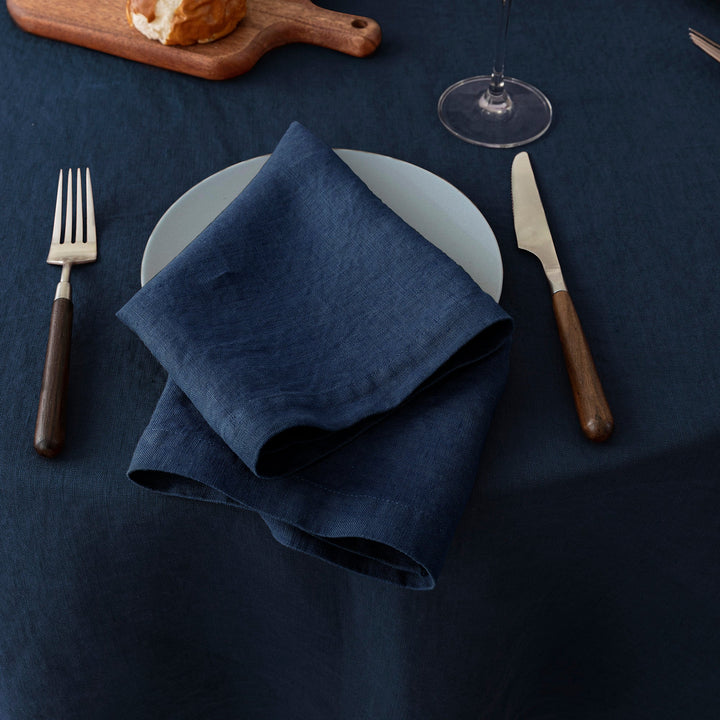 Luxurious navy blue linen napkin, folded into a classic rectangle for an elegant dinner setting.